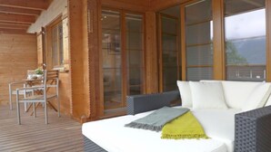 Eine Holzhütte mit einem Bett, einem Stuhl und einem Tisch.