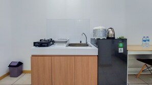 Pieni, käytännöllinen keittiönurkkaus, jossa on pesuallas, kahvinkeitin, vedenkeitin ja pieni jääkaappi.