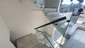 A modern staircase with glass railings and marble steps. - FIESTA MIRAMAR (Ciudad Madero)