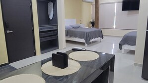 A modern hotel room with a dark marble bar, two beds, a TV, and a large mirror. - FIESTA MIRAMAR (Ciudad Madero)
