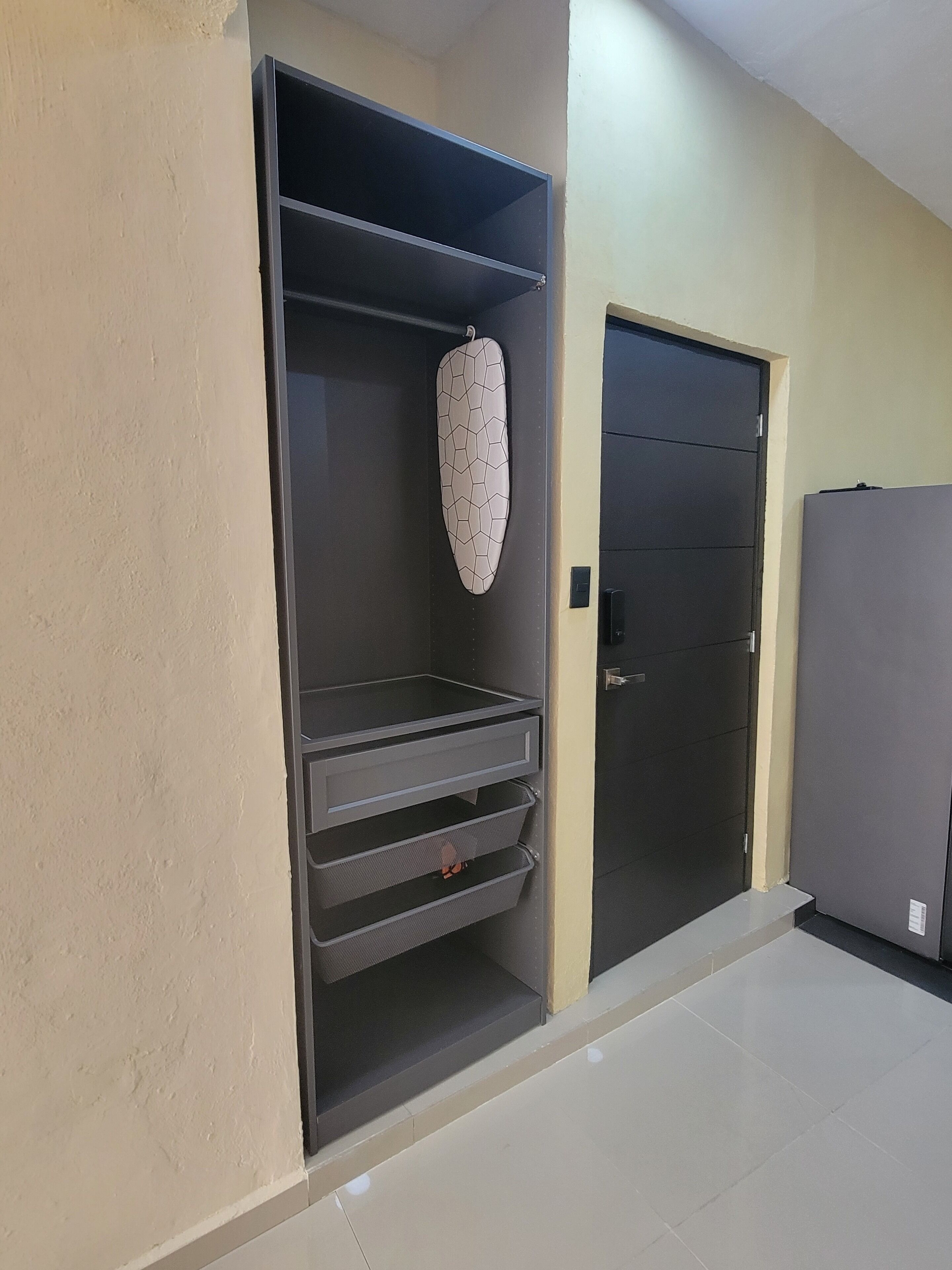 Una habitación con armario, puerta y refrigerador.