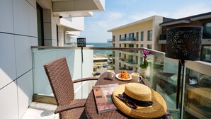Ein Balkon mit Korbmöbeln, einem Tisch mit Speisekarte, einem Hut und einem dekorativen Gegenstand.