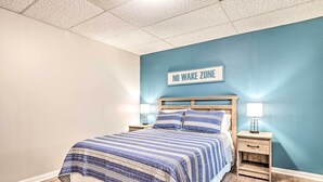 Un dormitorio con cama, mesitas de noche y un cartel en la pared que dice 'NO WAKE ZONE'.