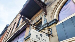 Un edificio con un letrero que dice "The Loft" y un balcón con barandilla de metal.