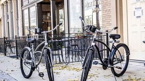 Varias bicicletas están estacionadas en la acera frente a un edificio con ventanas amplias y una puerta que dice "The Loft".