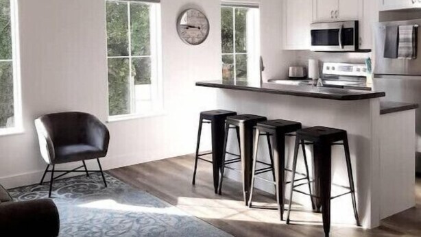 A spacious kitchen with a central island, bar stools, a ceiling fan, and large windows. - Two Bedroom Farmhouse Cottage No. 3
 (Orderville)