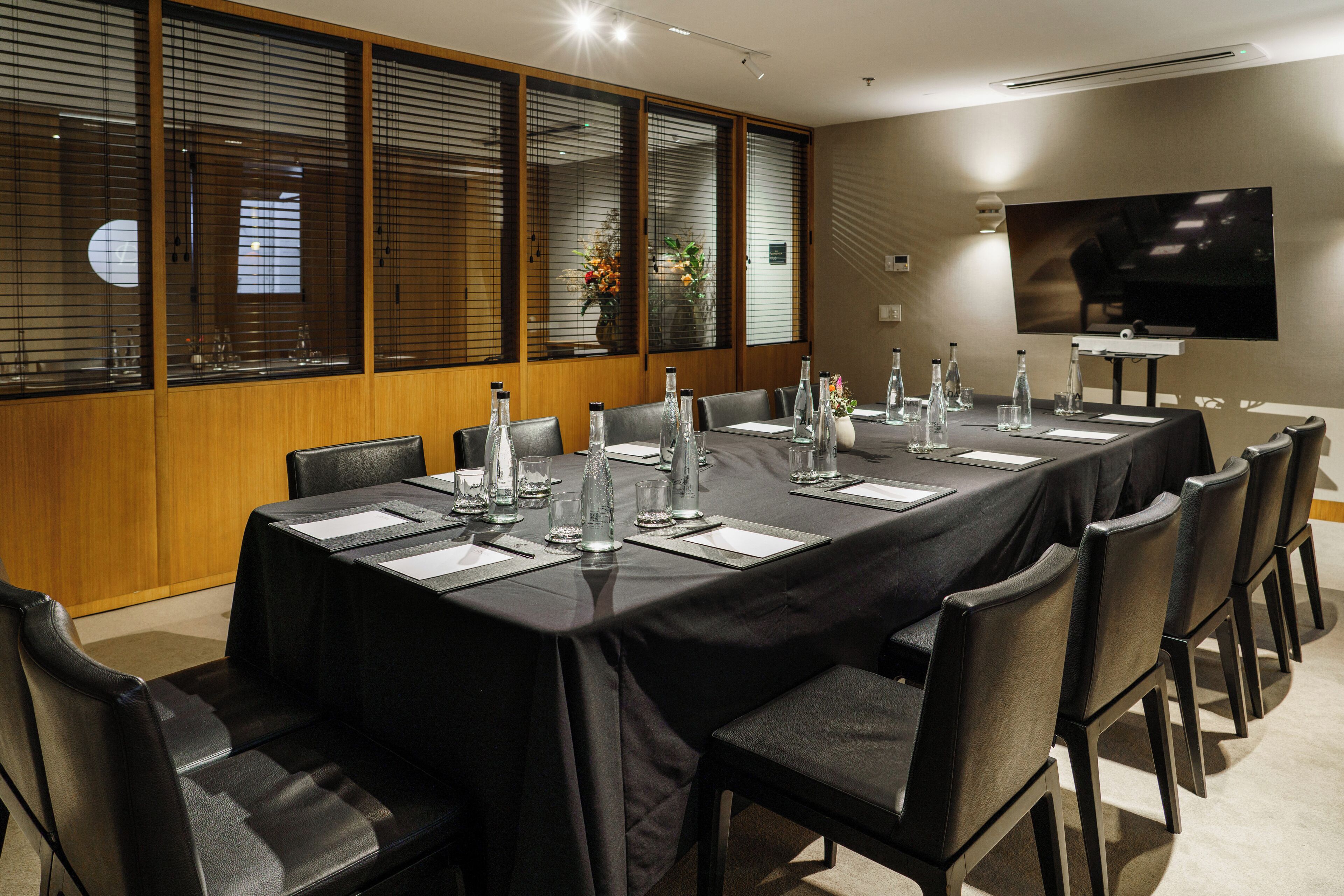 A conference room with a long table, black tablecloth, and matching chairs.