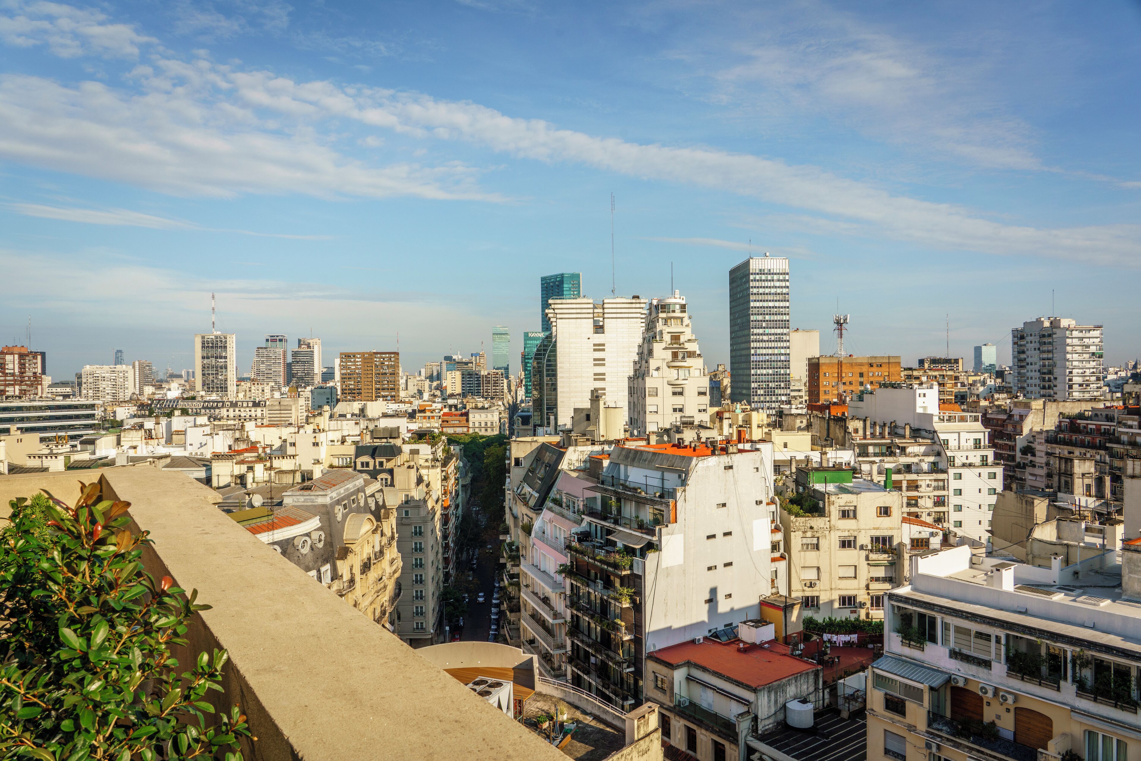 Un paisaje urbano con una variedad de edificios, incluyendo rascacielos y construcciones residenciales más pequeñas.