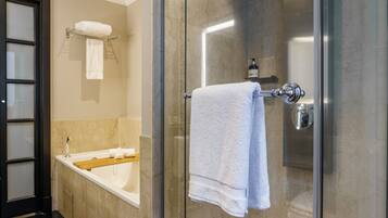 Ein modernes Badezimmer mit einer begehbaren Glasdusche, einer Badewanne und einem Handtuchhalter.