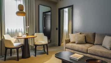 Et moderne hotelværelse med en sofa, to lænestole, et rundt bord og et sofabord.