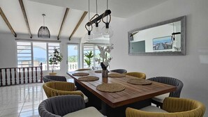 Ein Essbereich mit einem Holztisch, Stühlen und einer hängenden Leuchte.