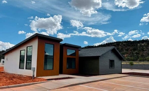 Situated in a landscaped area, this two-story building features a contemporary design with large windows and a flat roof.