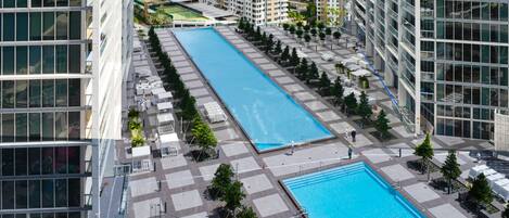 Ein moderner Stadtkomplex mit zwei rechteckigen Schwimmbecken und Hochhäusern.