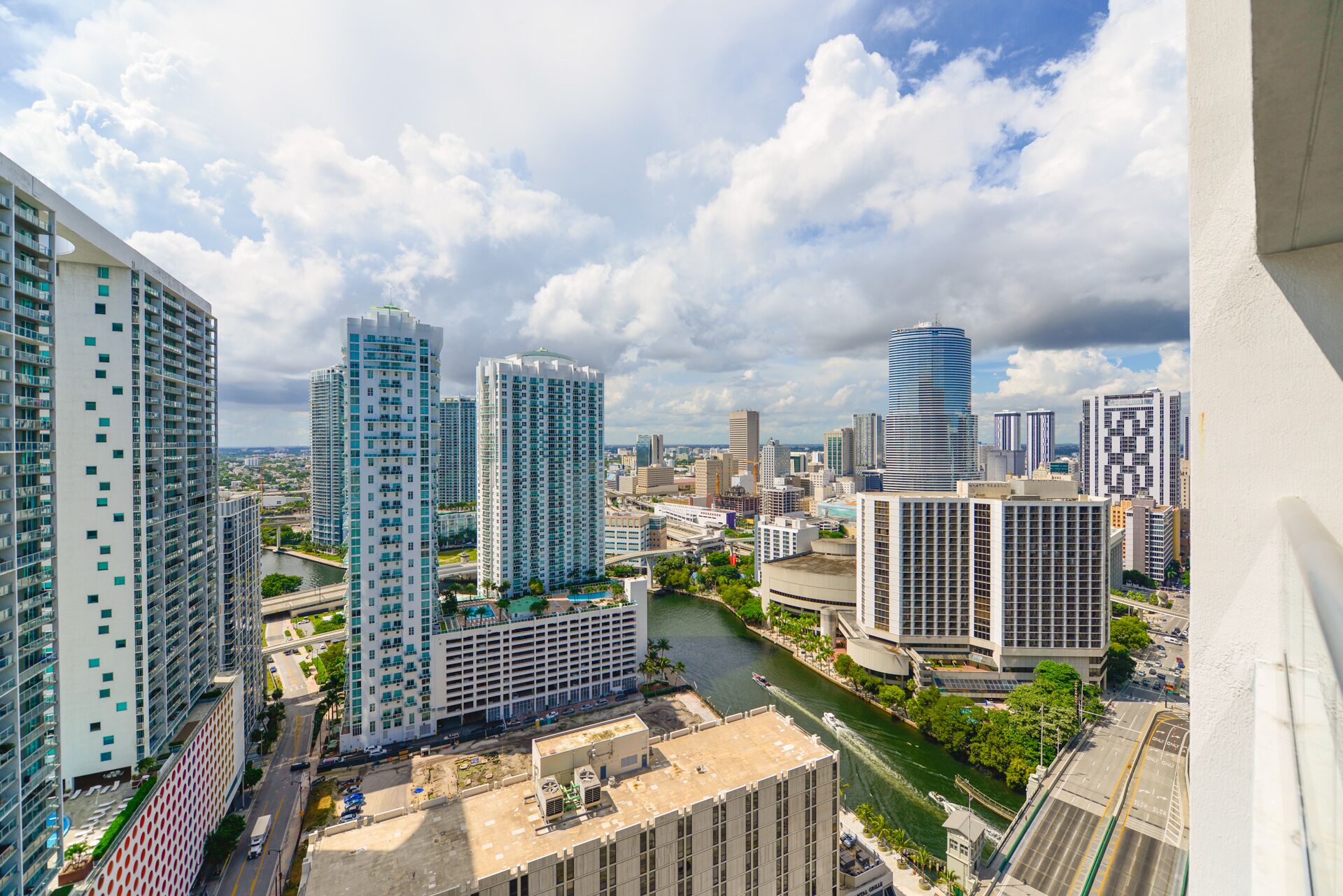 A high-rise urban area with modern buildings, a river, and a bridge.