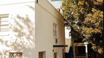 Un bâtiment blanc avec une enseigne indiquant « Little Mod Hotel » et un patio doté de sièges en plein air.