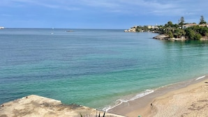A coastal view with clear turquoise waters, a sandy beach, and a rocky shoreline. - Villa OLEANDRA: Luxe, daily service, sea & sunset impressive views, 24mt pool (Isola)