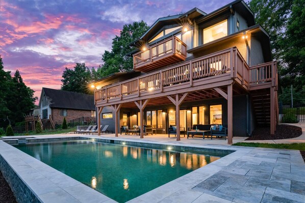 Relax on the covered deck with multiple levels, overlooking lush surroundings.