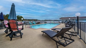 A poolside area with lounge chairs, a table, and umbrellas. - #10 Main Channel - King Room (Hot Springs)