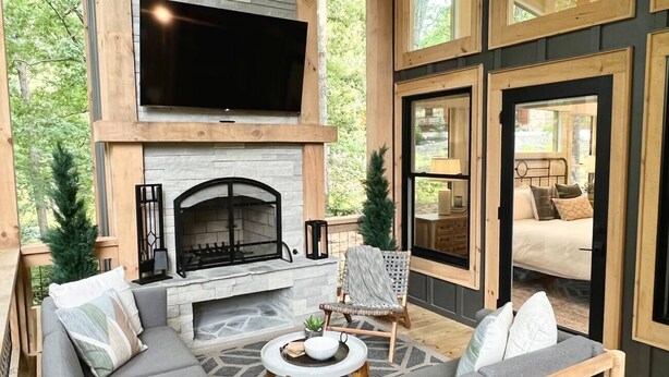A cozy outdoor living area with a fireplace, a sofa, a chair, and a coffee table.