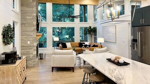 A spacious kitchen with a stone fireplace, a large dining area, and a cozy seating area with a sofa and chairs.