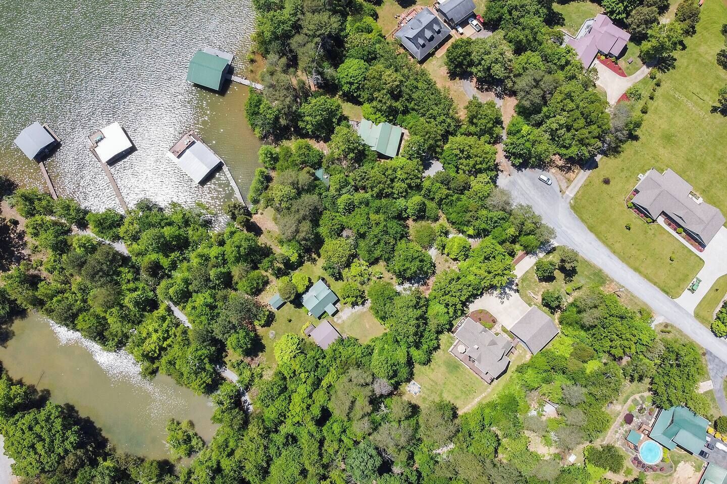 Vista aérea de una zona residencial con casas, piscina y río.