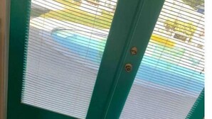 A teal door with a window, a doormat with "Coastal Turtle" and "Est. 2022" text, and a tiled floor. - Quaint Coastal Pool Home Oasis Florida Space Coast, by Beach&Space Coast Stadium (Melbourne)