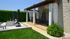 A patio with outdoor furniture, a stone wall, and a hedge. - Villa dado (Kanfanar)