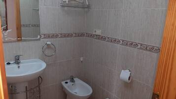 Een haardroger, handdoeken, zeep, toiletpapier