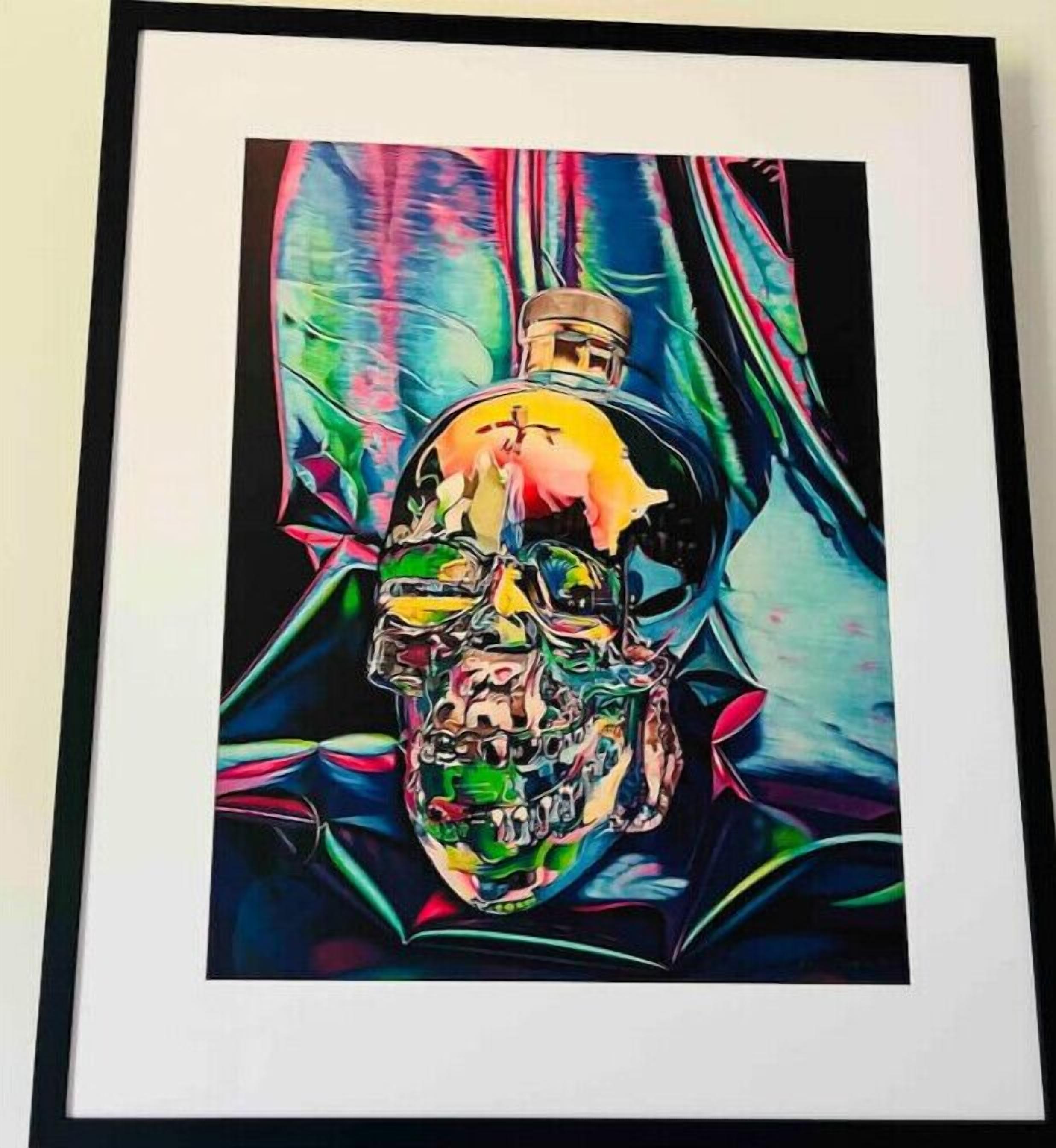 A framed artwork of a skull with a bottle, surrounded by abstract shapes and colors.