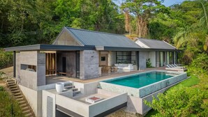 Una casa moderna con piscina, immersa nel verde.