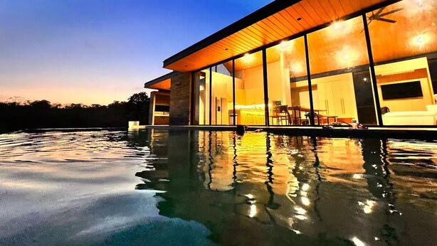 Una casa moderna con una piscina in primo piano.
