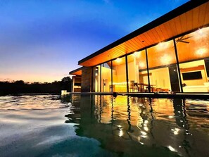 Et moderne hus med en swimmingpool i forgrunden.