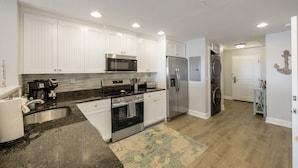A modern kitchen with white cabinets, stainless steel appliances, a built-in oven, and a microwave. - Waterfront, Harbourside, Water Park, Beach, #5516 (Indian)