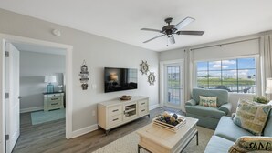 A living room with a TV, a ceiling fan, a sofa, and a coffee table. - Waterfront, Harbourside, Water Park, Beach, #5516 (Indian)