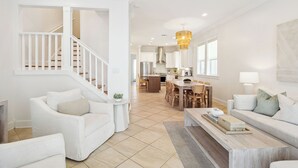 A spacious living area with a staircase, a dining area, and a kitchen.