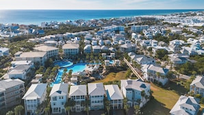 Zona residencial costera con varios edificios, una piscina central y vista al océano.