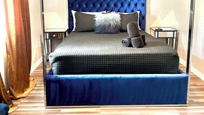 A bedroom with a four-poster bed, a ceiling fan, and a nightstand with a lamp. - Unique space with lots of details! (Seffner)