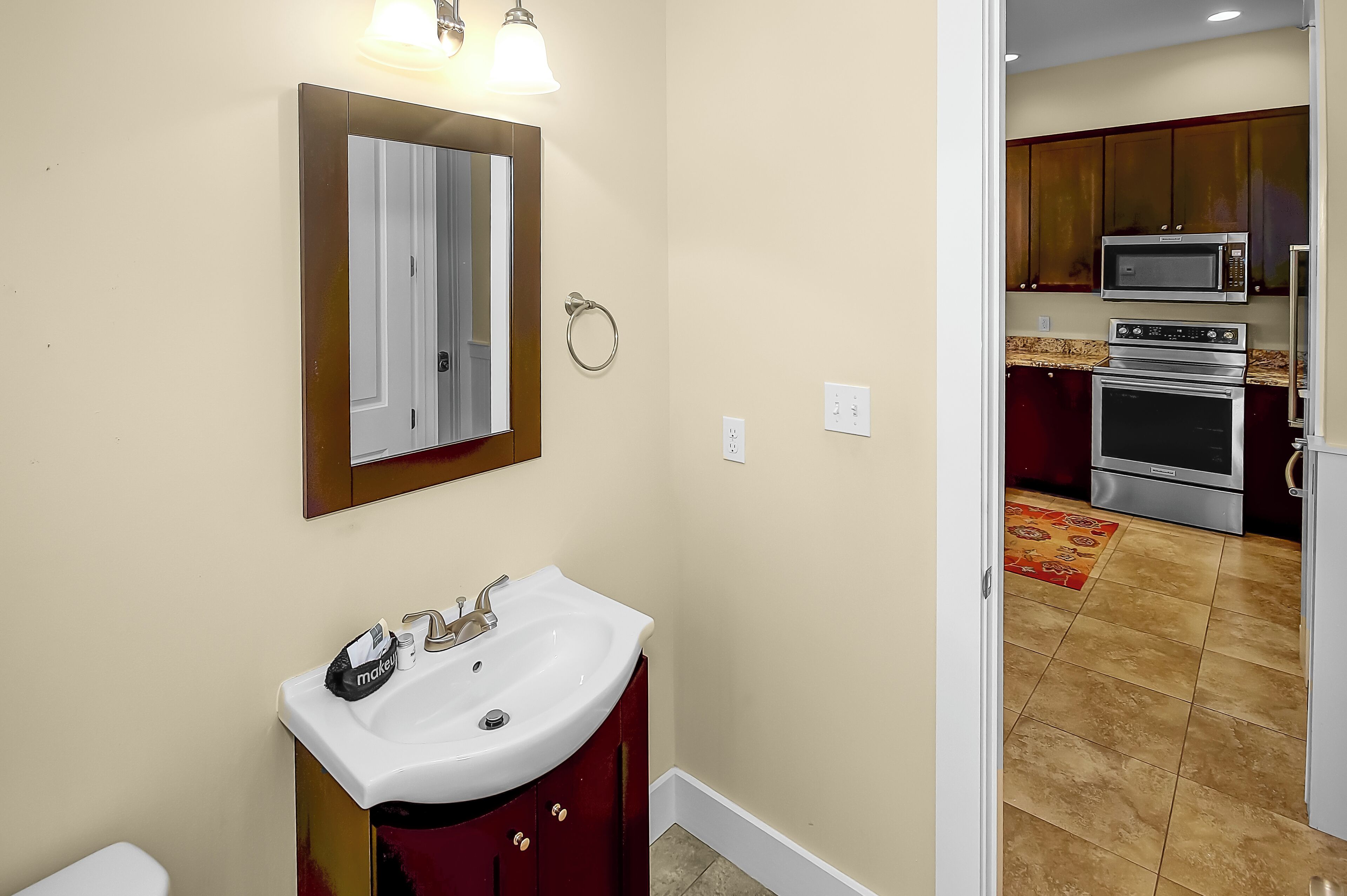 A bathroom with a sink, mirror, and a toilet.