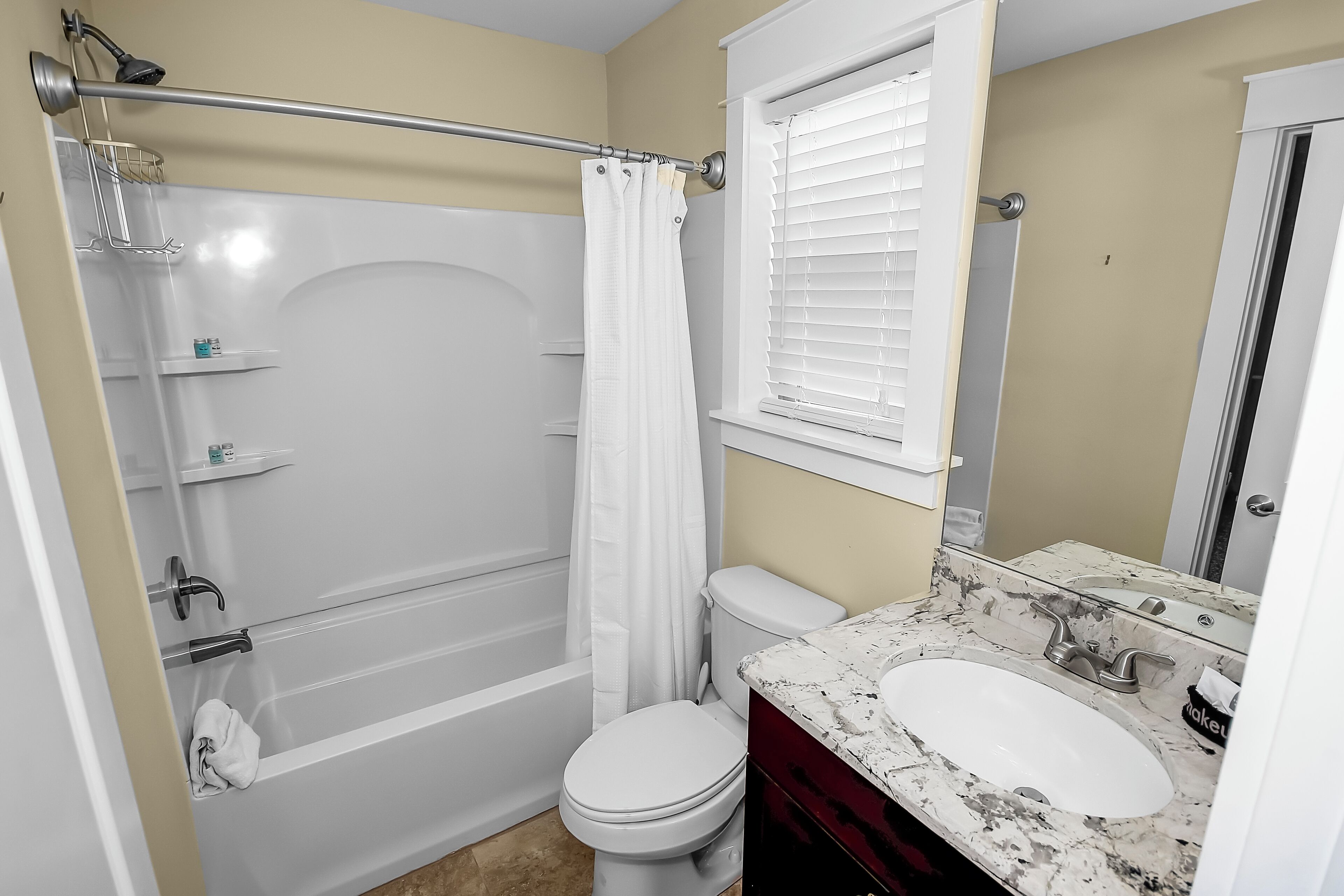 A bathroom with a bathtub, toilet, and sink.
