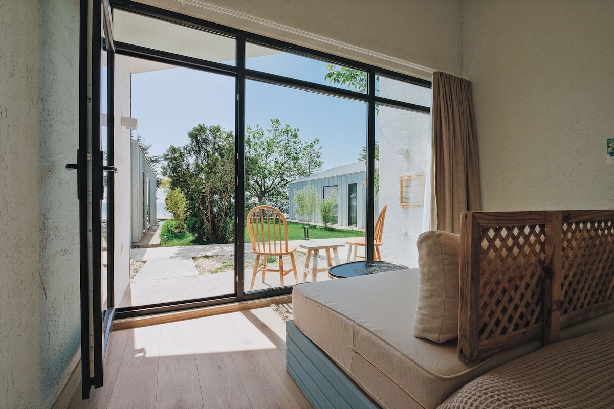 A room with a large sliding glass door leading to an outdoor patio with a table and chairs.