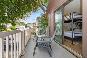 A balcony with two chairs and a bunk bed.