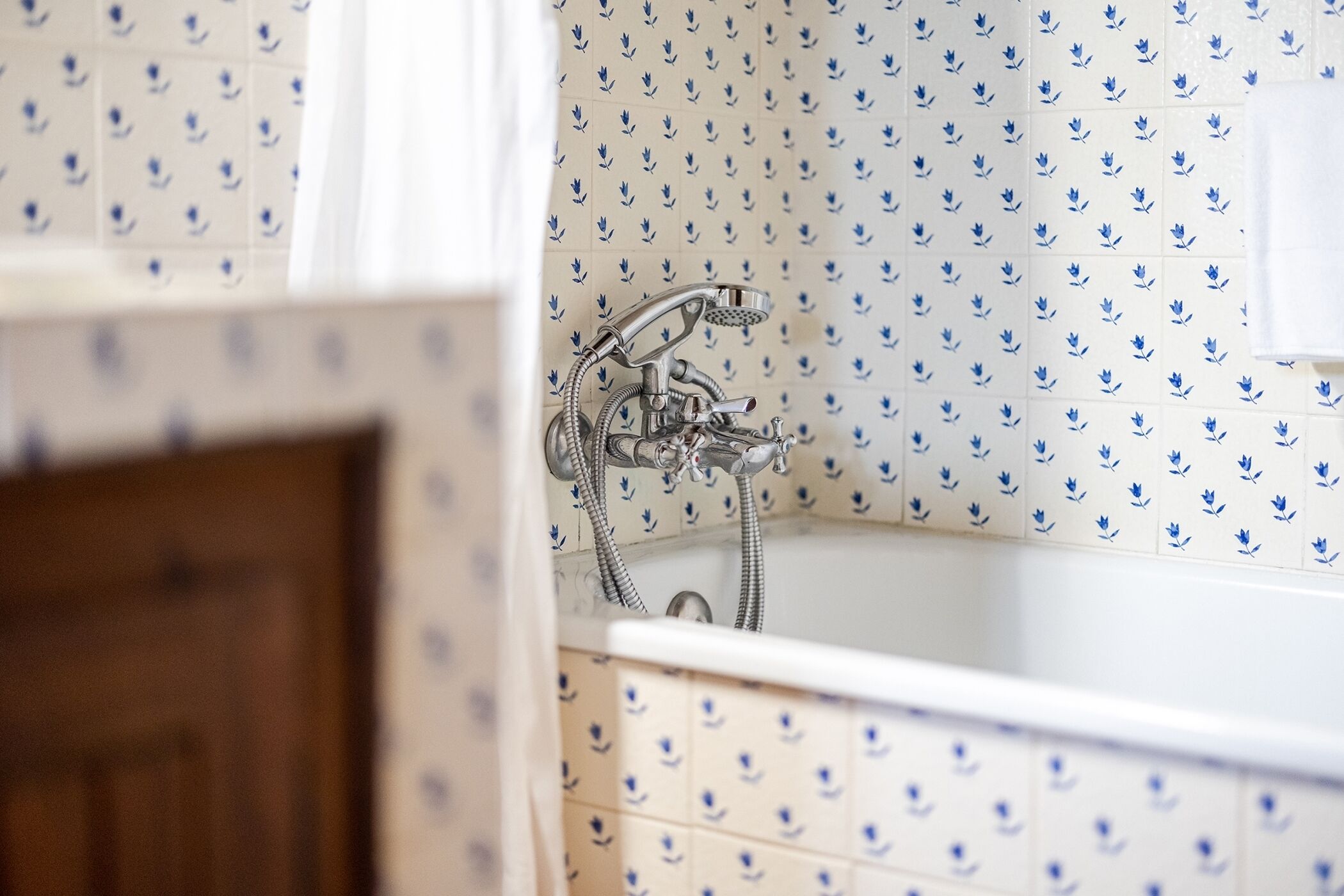 A bathroom with a bathtub, shower, and tiled walls.