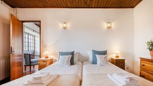 Habitació d'hotel amb dos llits, sostre de fusta i dues làmpades penjades a la paret.