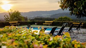 Ein Poolbereich mit Liegestühlen und Blick auf die Landschaft.