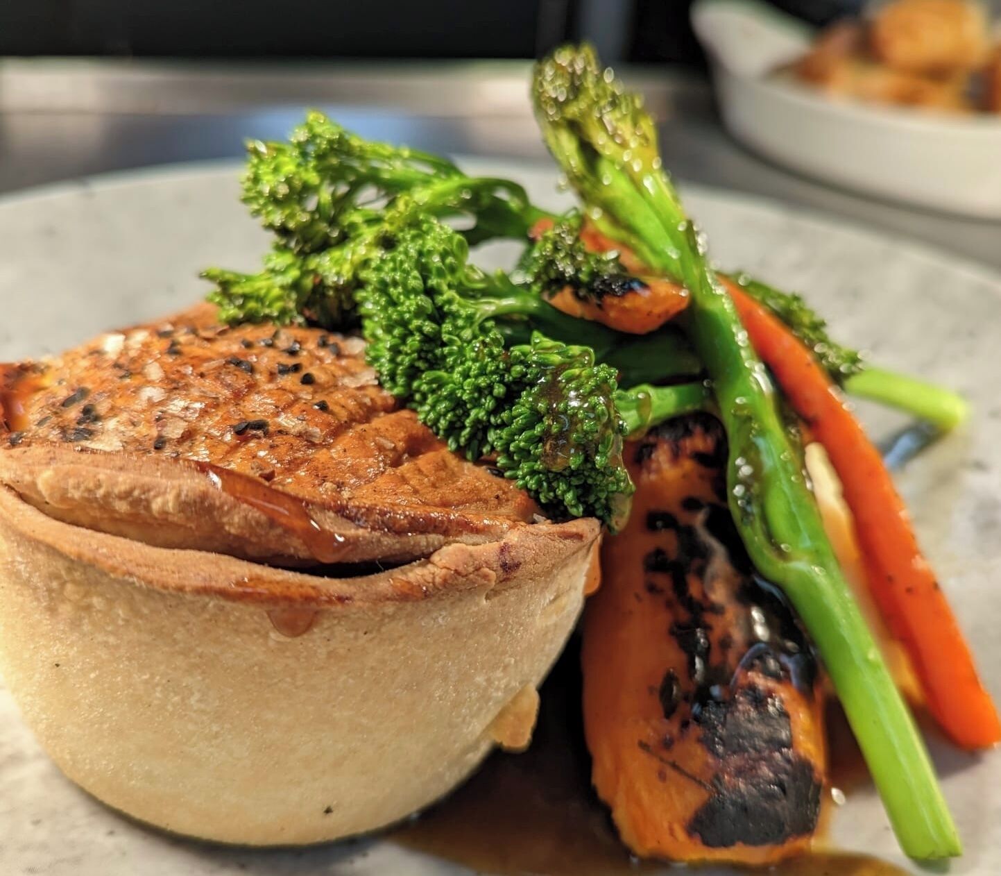 Een maaltijd met een hartige taart, broccoli en gegrilde groenten.