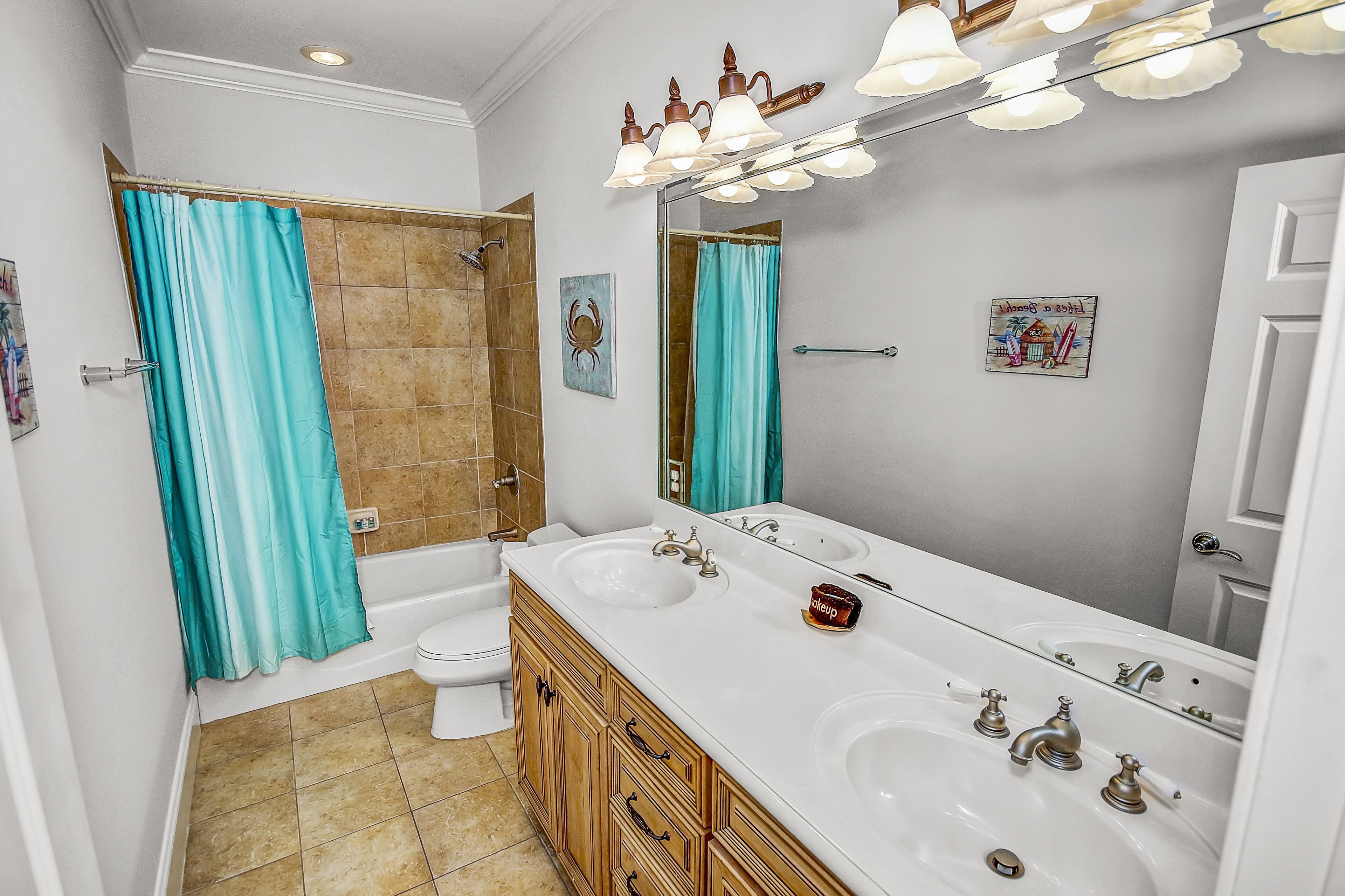 A bathroom with a double sink vanity, a shower, and a toilet.
