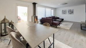A modern living room with a sofa, coffee table, and dining table. - Nice home in Helsingborg (Helsingborg)