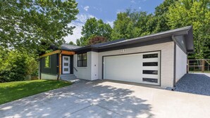 A modern two-story house with a garage, a covered porch, and a well-maintained lawn. - Mid-century Modern Remodel near Pisgah & Asheville (Asheville)