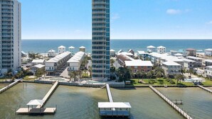 Zona hotelera costera con edificios modernos, un puerto deportivo y una vista despejada del océano.
