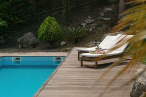A wooden deck with a pool, lounge chairs, and a small tree. - Casa do Vale - Nature Retreat with Private Pool (Óbidos)